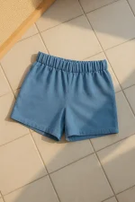 Açık okyanus mavisi tonlarında, elastik belli kadın keten şort; karo desenli açık zemin üzerinde sergilenmiş.